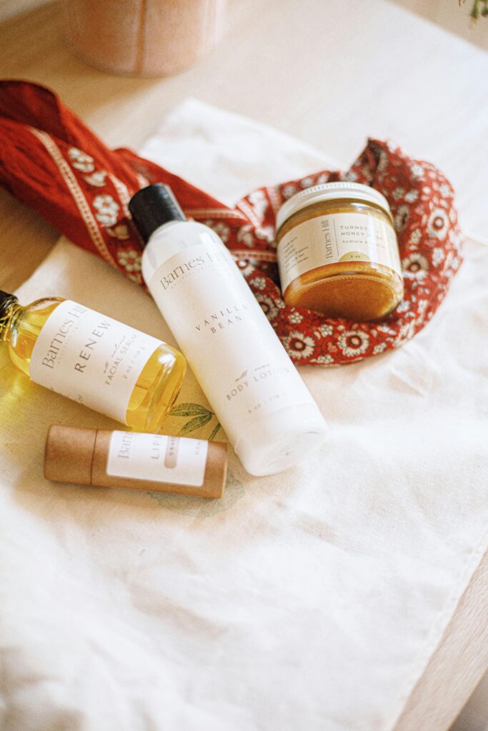 Flatlay of artisan skincare products with natural ingredients and minimal packaging in warm tones.